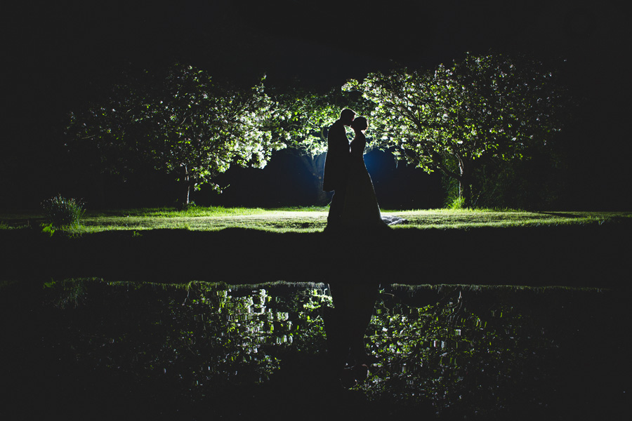dramatic wedding photos reflection over water at night