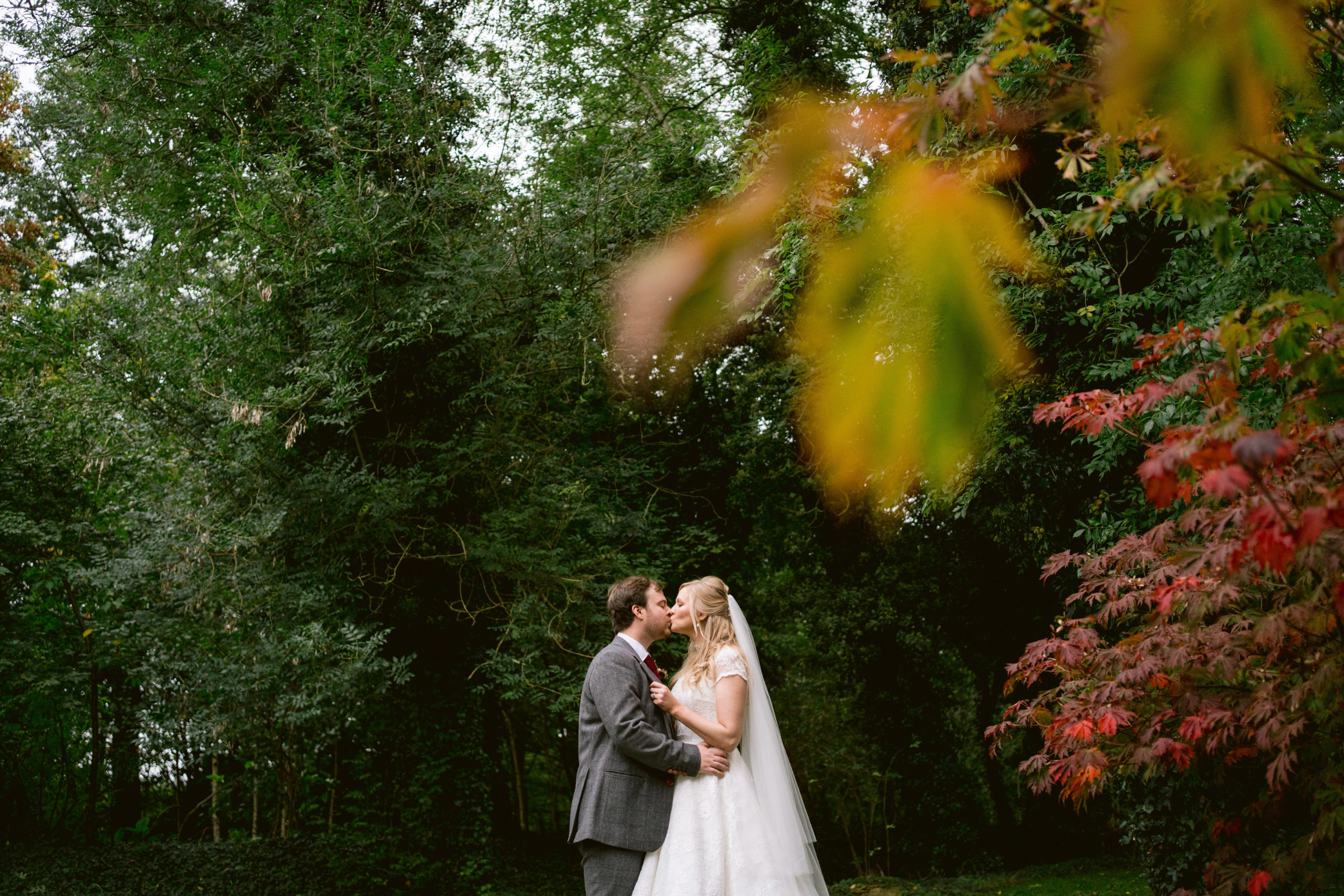 bride and groom kissing in the grounds of cripps barn