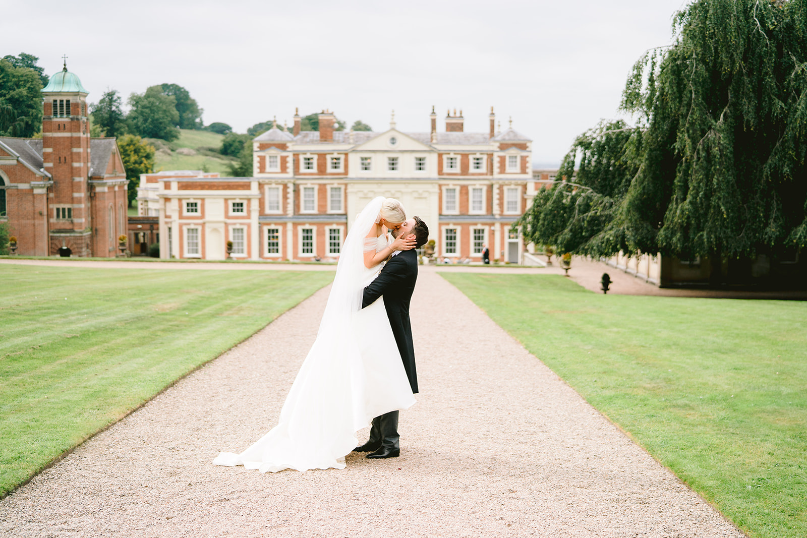 hawkstone hall wedding photographer groom picking up bride with hall in background
