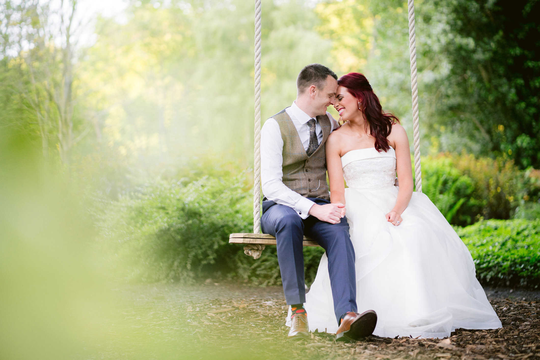 bride and groom sat on the swing at their tyn dwr hall wedding